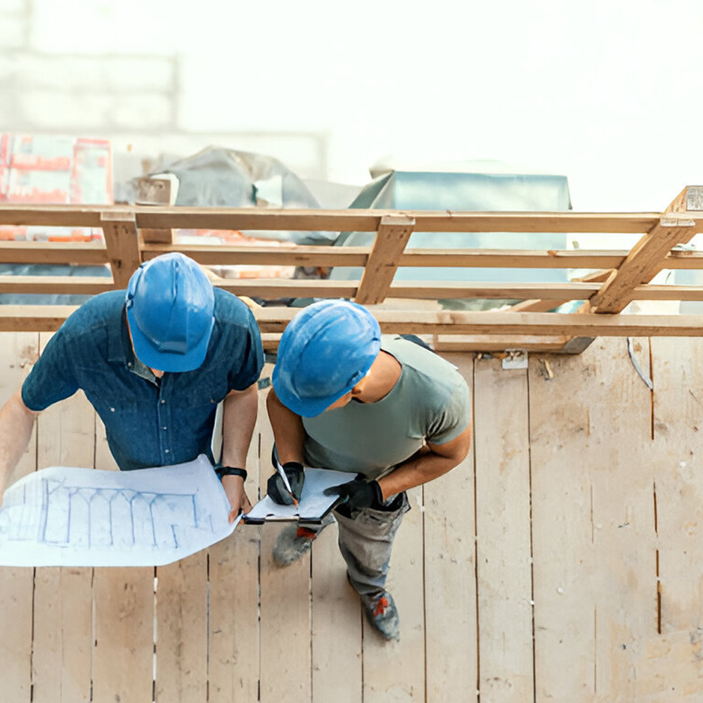 Engineers in hard hats reviewing site plans